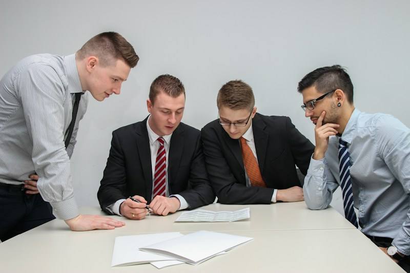 Team reviewing documents around a table, representative image