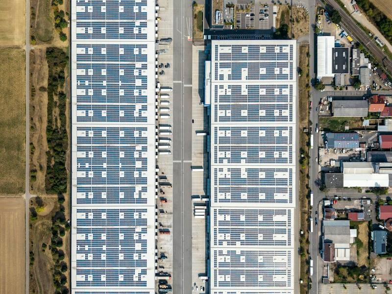 Industrial warehouses with solar panels on their roofs, representative image