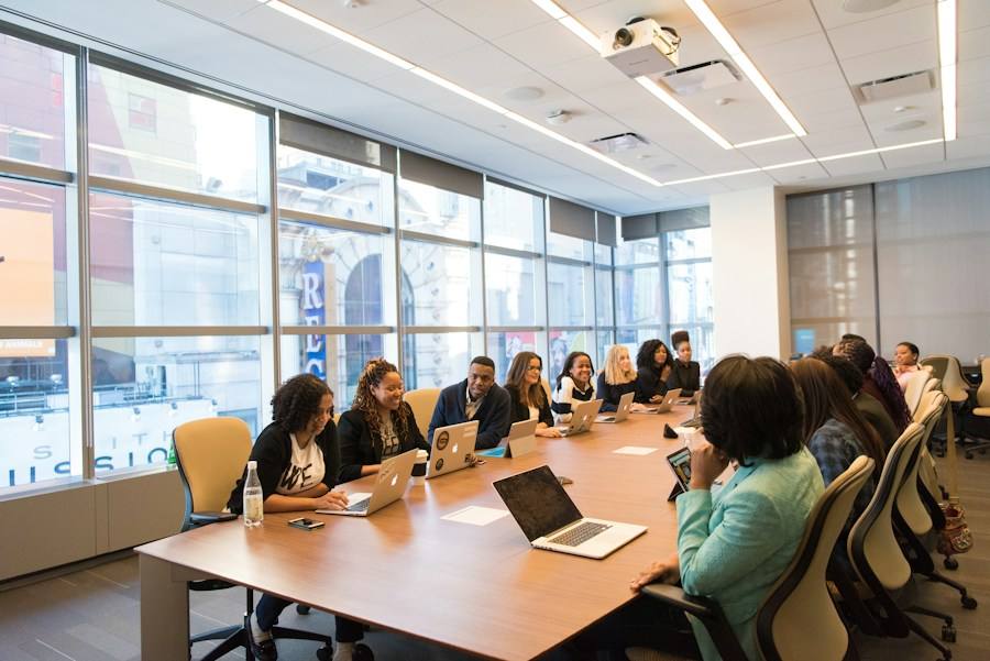 Team meeting around a table with laptops, representative image